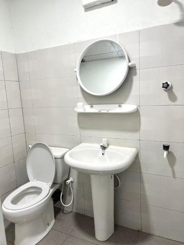 a bathroom with a toilet and a sink and a mirror at lagoon holiday villa Jaffna in Tavadi
