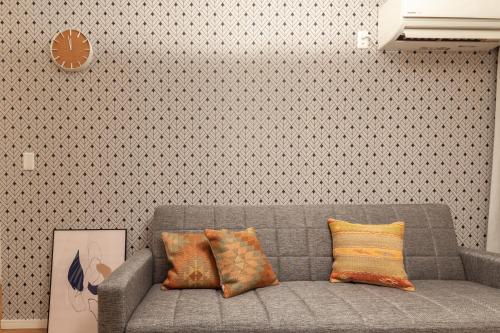 a living room with a gray couch with pillows at Eldor Nishikoujiya Apartment by Tranova in Tokyo