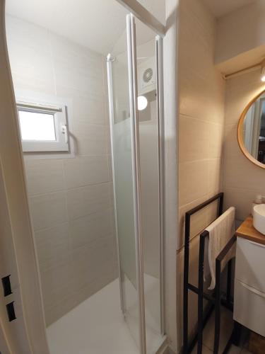 a shower with a glass door in a bathroom at Le petit château de sable in Valras-Plage