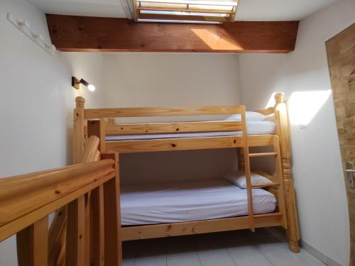 two bunk beds in a room with a window at Le petit château de sable in Valras-Plage