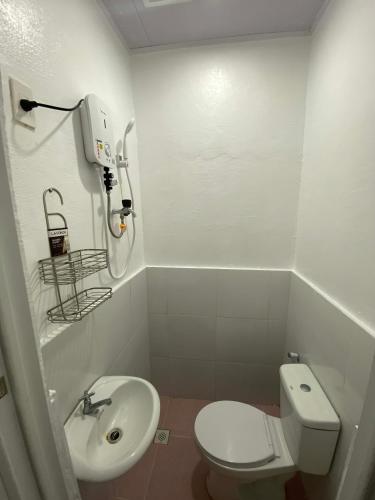 a small bathroom with a toilet and a sink at JEHH8 Guest House in Siquijor