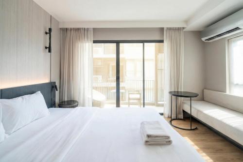 a bedroom with a white bed and a couch at Bayphere Residence by Prop Hopper in Na Jomtien