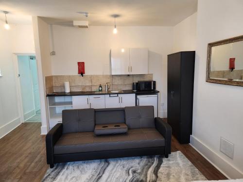 a living room with a couch in front of a kitchen at Double room in Stone in Kent