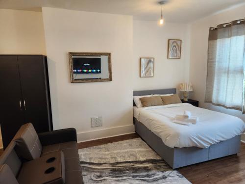 a bedroom with a bed and a tv on the wall at Double room in Stone in Kent