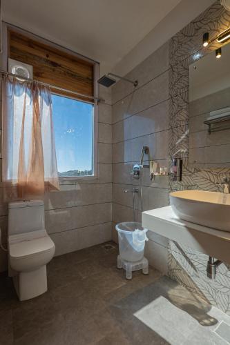 a bathroom with a sink and a toilet and a tub at The Golden Castle Hotels in Mukteshwar