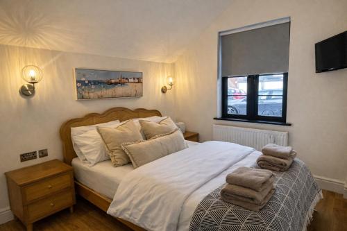 a bedroom with a bed with towels on it at Beach Retreat, Stylish 1-Bed in Canford Cliffs in Canford Cliffs