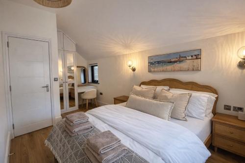 a bedroom with a large white bed and a desk at Beach Retreat, Stylish 1-Bed in Canford Cliffs in Canford Cliffs