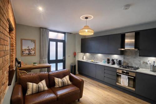 a living room with a couch and a kitchen at Beach Retreat, Stylish 1-Bed in Canford Cliffs in Canford Cliffs
