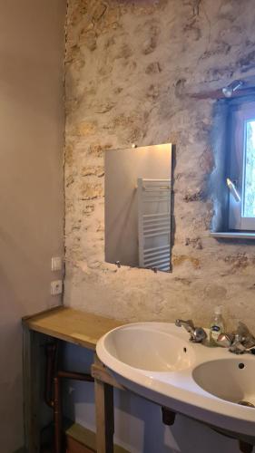a bathroom with a sink and a mirror at Gîte du caveau in Marcorignan