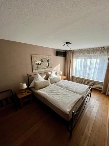 a bedroom with a bed with white sheets and a window at stylish suite OldTown free parking Air Condition in Heidelberg