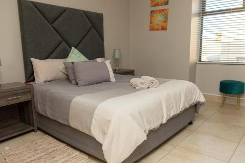 a bedroom with a large bed with two towels on it at Don Self Catering in Walvis Bay