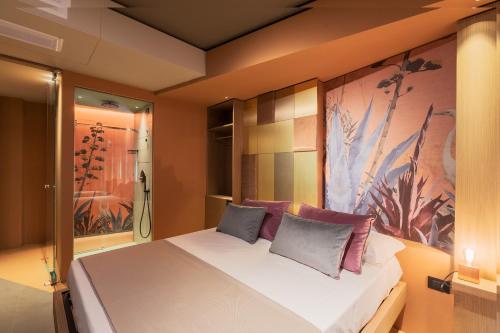 a bedroom with a bed and a painting on the wall at Dimora San Girolamo Luxury Apartments e Rooms in Marsala