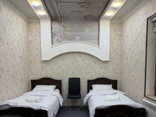 a bedroom with two beds and a mirror on the wall at Hostel Azizjon in Samarkand