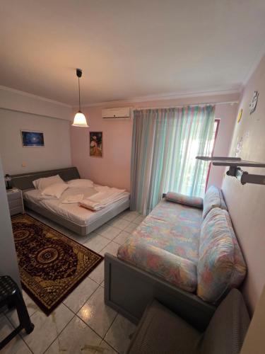 a bedroom with a bed and a couch and a window at Ariadni's Dreamhouse in Akrata