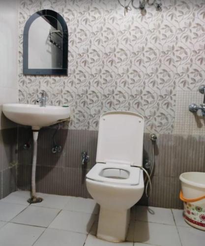 a bathroom with a toilet and a sink at The Gopi Dham Hotel in Haridwār