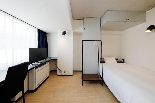 a bedroom with a bed and a desk and a television at Piazza-U Yutenji by Tranova in Tokyo