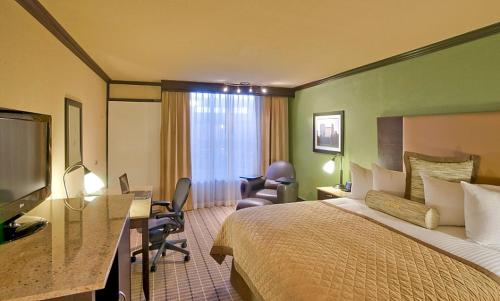 a hotel room with a bed and a desk at Citrus Suites Oklahoma City Airport Buffet Breakfast Included in Oklahoma City