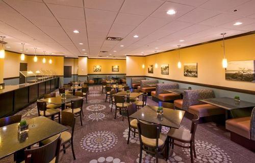 a restaurant with tables and chairs in a room at Citrus Suites Oklahoma City Airport Buffet Breakfast Included in Oklahoma City