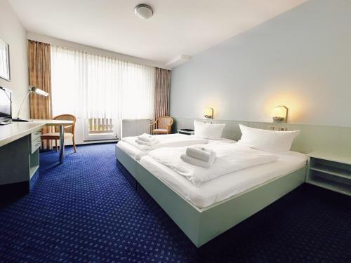 a hotel room with a large bed and a television at WAGNERS Sporthotel Oberhof in Oberhof