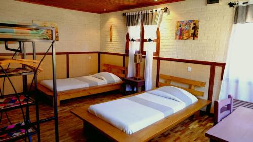 アンツィラベにあるEco Lodge Les Chambres Du Voyageurのベッド2台と二段ベッド1組が備わる客室です。