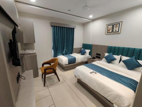 a hotel room with two beds and a television at Hotel Signature Bopal in Ahmedabad