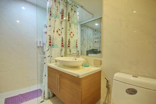 ein Badezimmer mit einem Waschbecken, einem WC und einem Spiegel in der Unterkunft My Resort Hua Hin A304 in Hua Hin