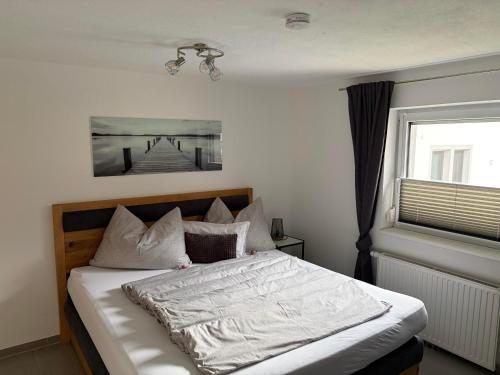 a bedroom with a bed with white sheets and a window at Apartment in der Au in Langkampfen