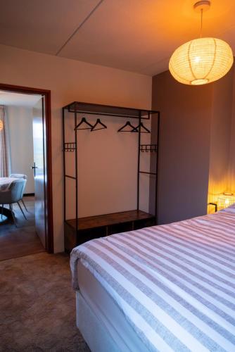 a bedroom with a bed and a chandelier at Vakantiewoning de Hofmeier in Benteloo