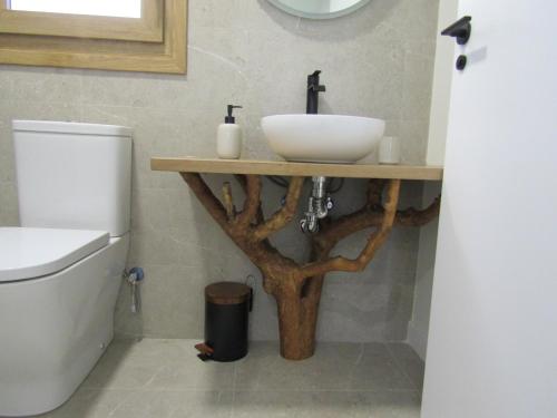a bathroom with a sink on a wooden stand next to a toilet at La Alcoholera in Valtierra