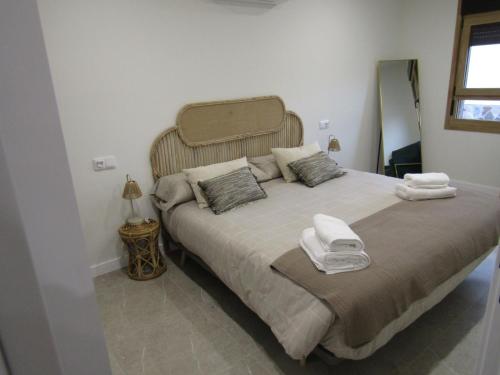 a bedroom with a large bed with towels on it at La Alcoholera in Valtierra
