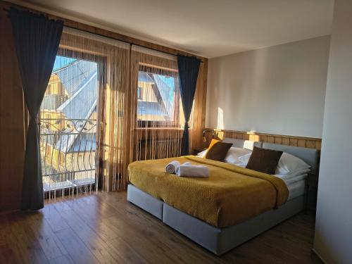 a bedroom with a bed and a large window at Sądelska Chałpa in Murzasichle