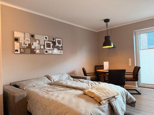 a bedroom with a bed and a table and a window at Ankertau in Norden