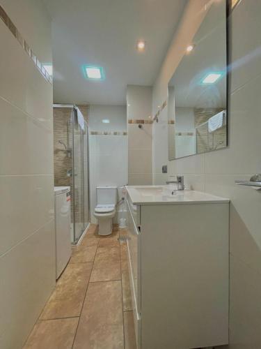 a white bathroom with a toilet and a sink at Terrasol Pirámides Puerto Blanco in Caleta De Velez
