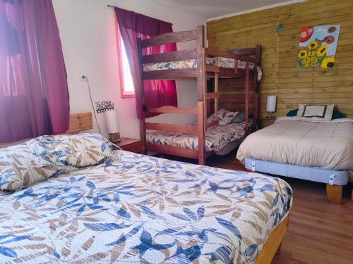 a bedroom with two beds and a bunk bed at Casona Mamalluca in El Durazno