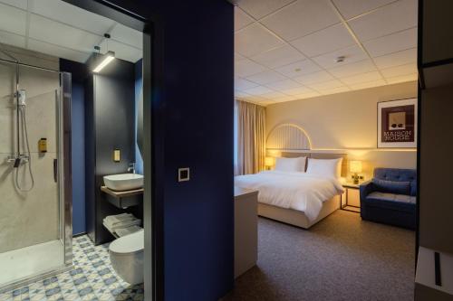 a hotel room with a bed and a bathroom at Yuko Residence in Jasło