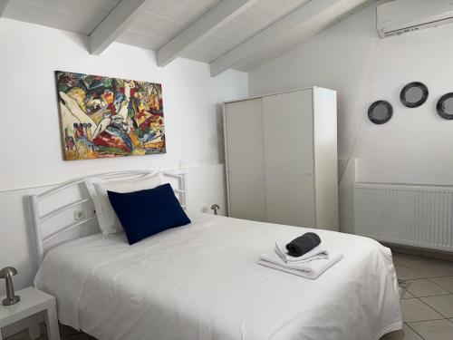 a bedroom with a white bed with a painting on the wall at Sideroporta castle Náfpaktos in Nafpaktos