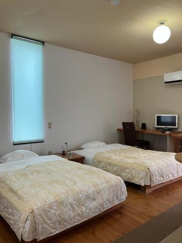 a hotel room with two beds and a large window at Green House Tsukuba Studio in Tsukuba