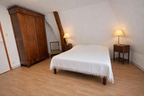 a bedroom with a white bed and a wooden floor at Gîte Le Haut-Perché, 4 personnes in Saint-Gervais-la-Forêt