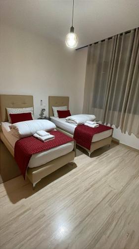 two twin beds in a room with wooden floors at Suites Appartement Midelt in Midelt