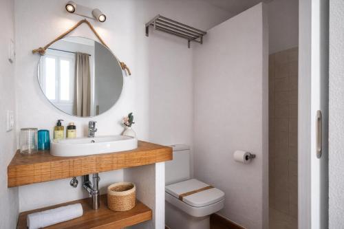 a bathroom with a sink and a toilet and a mirror at Hotel Boutique Ses Penyes in Alaior