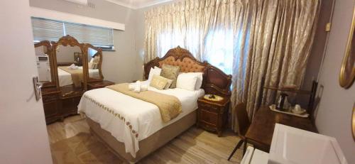 a bedroom with a large bed and a large mirror at Sthuli House in Empangeni