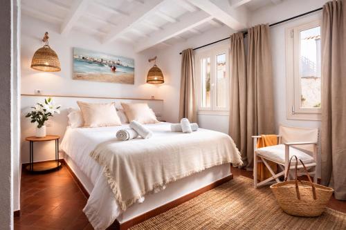 a white bedroom with a bed and a window at Hotel Boutique Ses Penyes in Alaior
