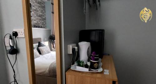 a room with a bedroom with a bed and a mirror at The Celtic Pride Hotel in Blackpool
