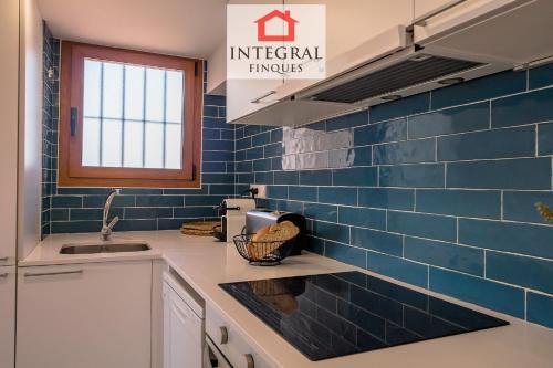 a kitchen with blue tiles on the wall at Palamós Blue Holidays in Palamós