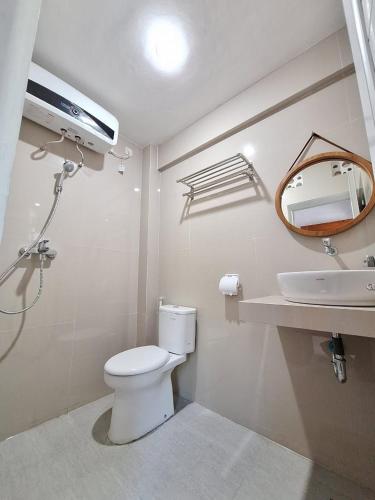 a bathroom with a toilet and a sink and a mirror at MIN Guest House Watukarung in Pacitan