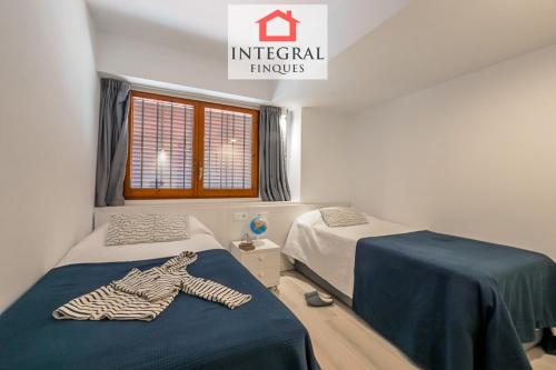 a room with two beds and a zebra robe on the bed at Palamós Blue Holidays in Palamós