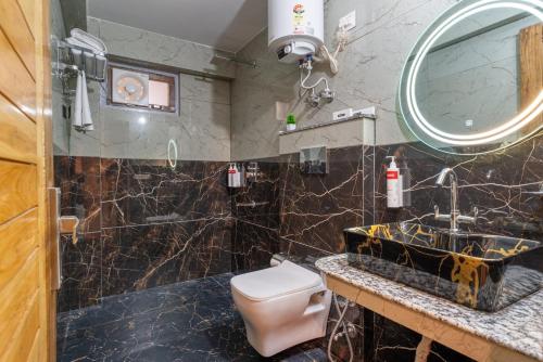 a bathroom with a toilet and a sink and a mirror at Moustache Hostel Nainital in Nainital