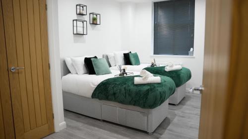 a bedroom with two beds and a sink with towels at The Emerald Residence - Leicester - City Centre, Sofa Bed, Parking, Free WiFi, Netflix in Leicester