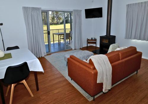 a living room with a couch and a table at Beltana Villas in Pokolbin