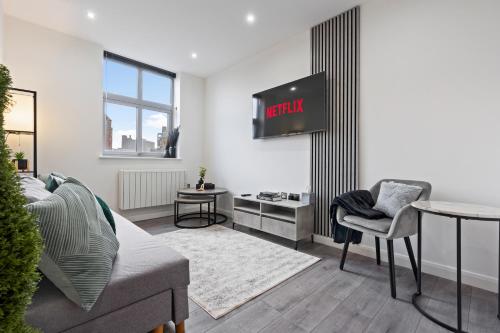 a living room with a couch and a table at The Emerald Residence - Leicester - City Centre, Sofa Bed, Parking, Free WiFi, Netflix in Leicester